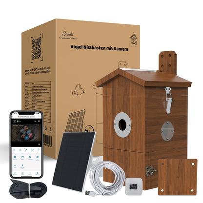 Holz-Vogelnistkasten mit integrierter Kamera, Solarpanel, USB‑Kabel, Montageplatte, Befestigungsgurt und Smartphone‑App‑Anzeige neben Verpackung